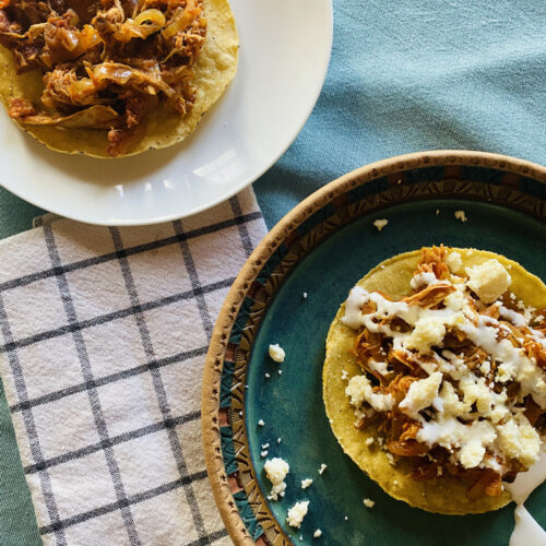 Two chicken tinga plates, one with cream and cheese, the other plain