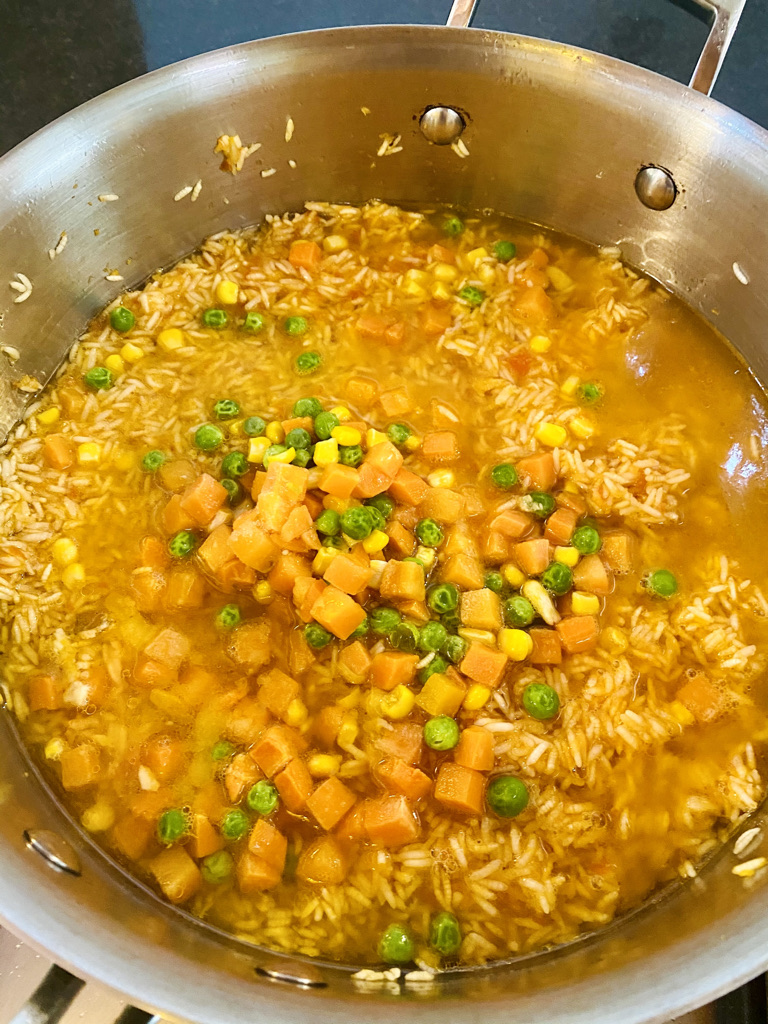 Broth, vegetables and salt added to rice