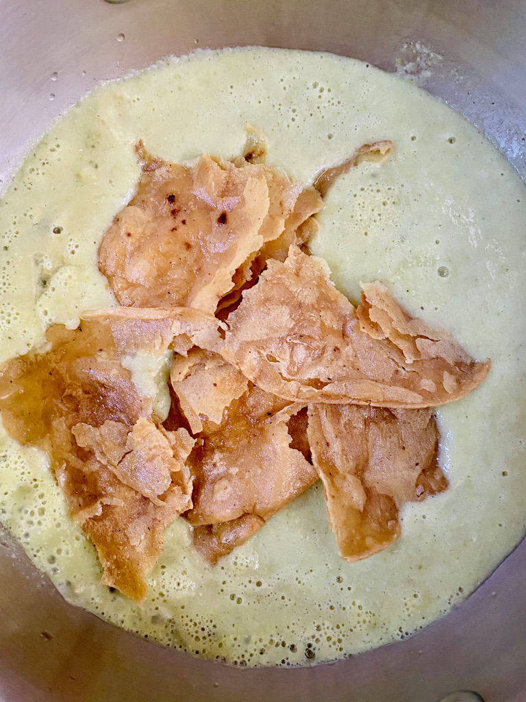 Fried tortillas are torn by hand and added to chilaquile sauce