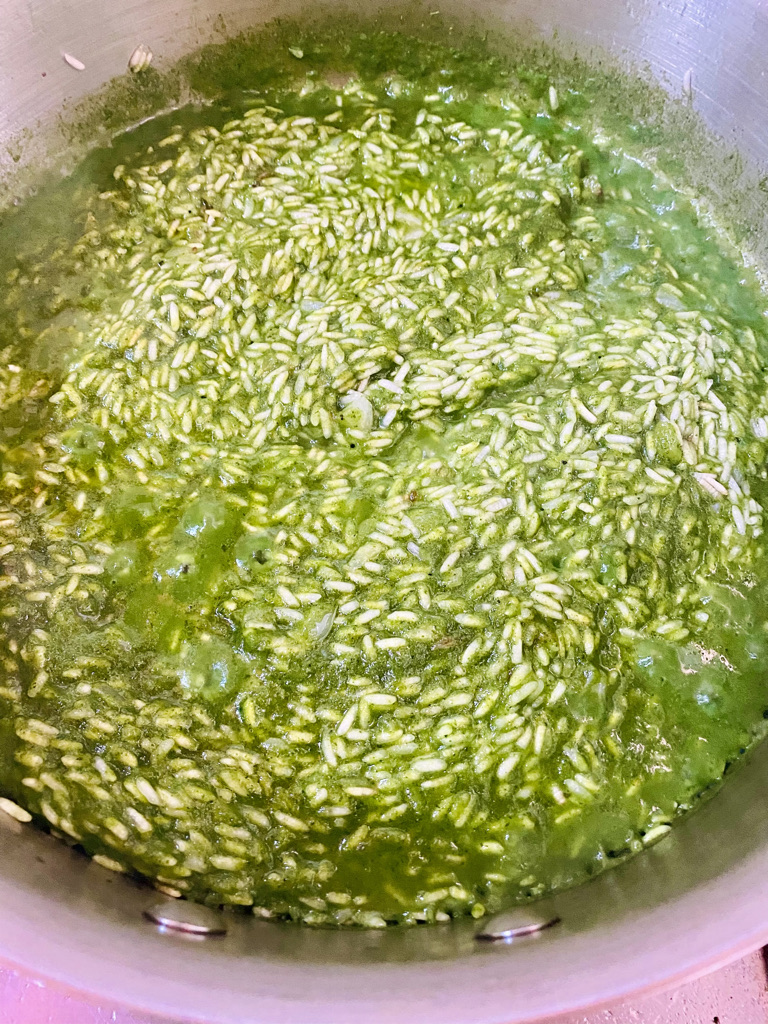 Green rice simmering on stove