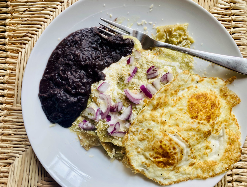Chilaquiles suizos with fried egg and refried black beans