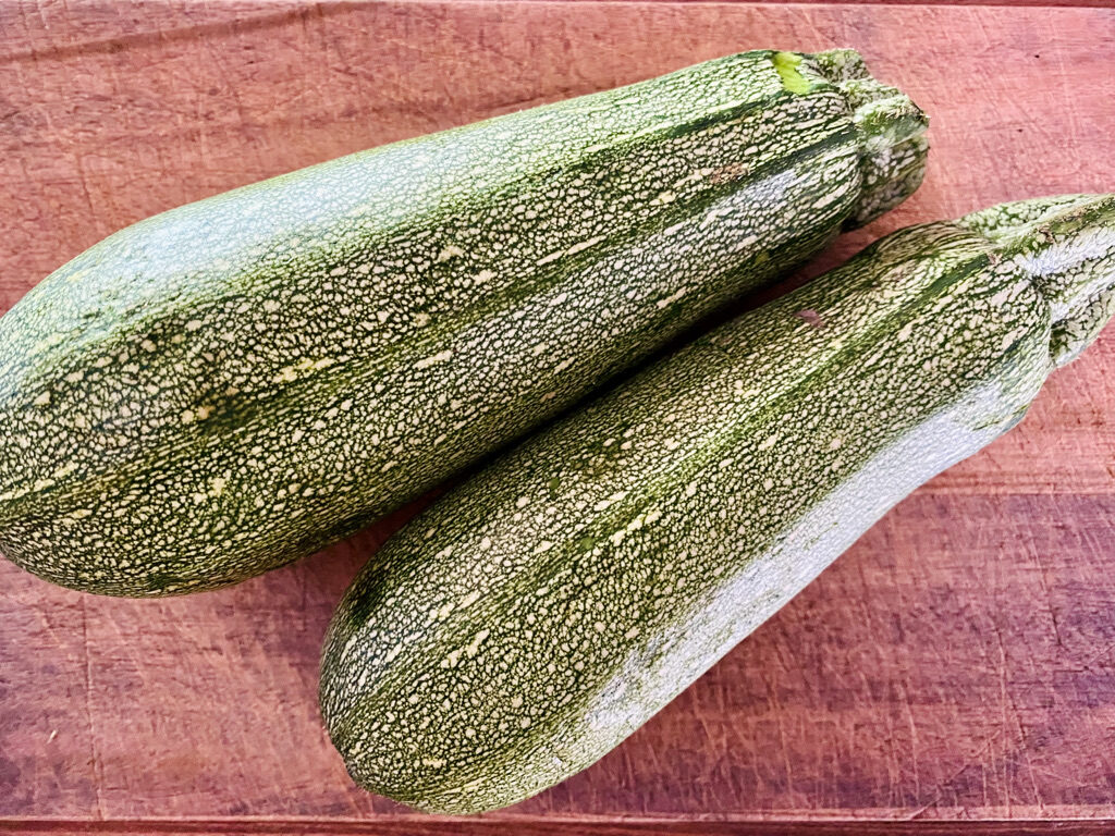 2 Mexican grey squashes on a wooden cutting board