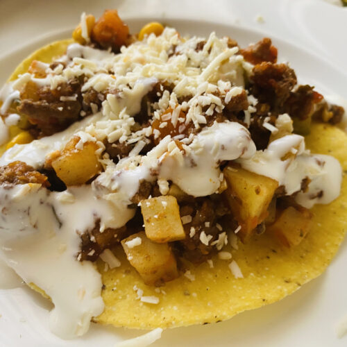 Easy Mexican Picadillo topped with Mexican cream and shredded queso cincho