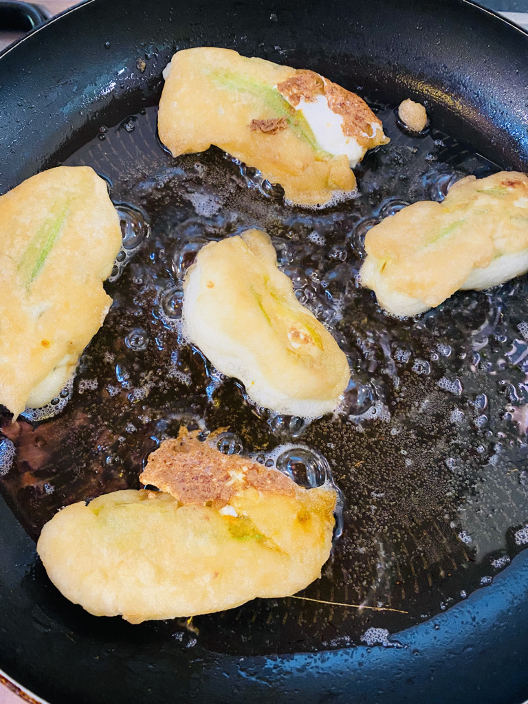 Stuffed squash blossom fritters frying