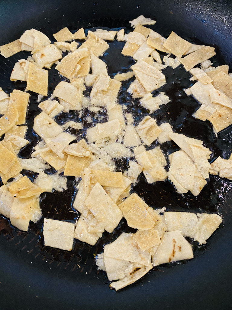 Tortilla pieces frying in oil