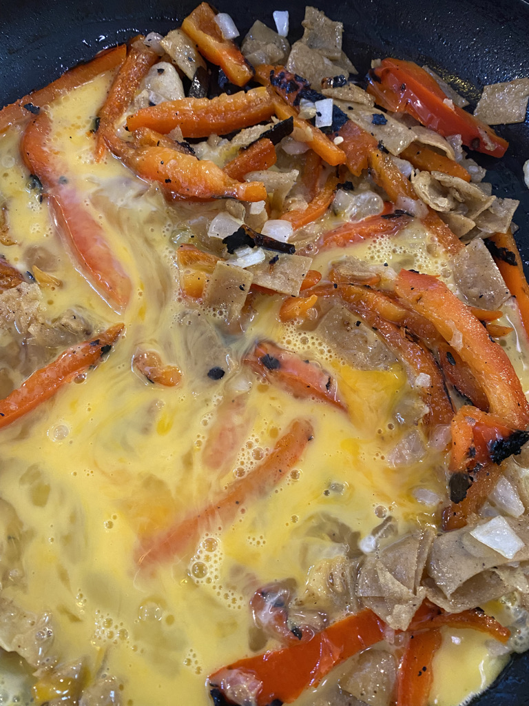 Eggs in pan with migas ingredients