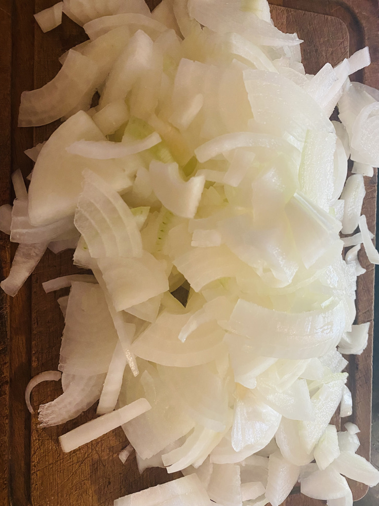 sliced white onions on wooden cutting board