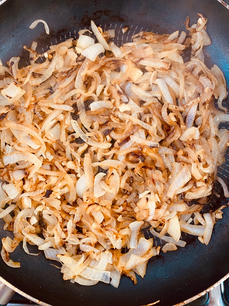 Golden brown onions frying in a non-stick skillet
