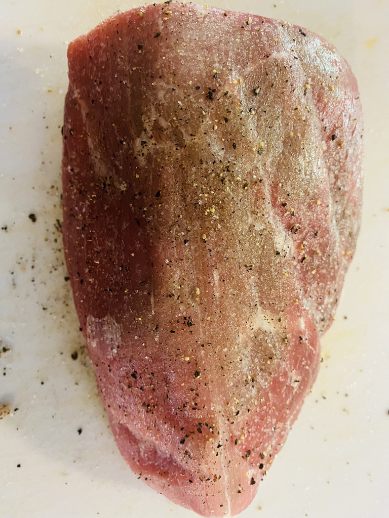 Boneless round roast seasoned with salt and pepper