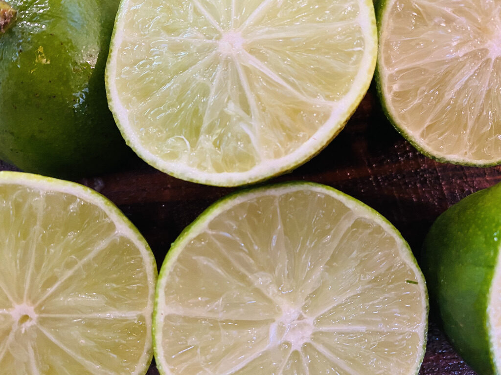 Cut limes on a wooden cutting board