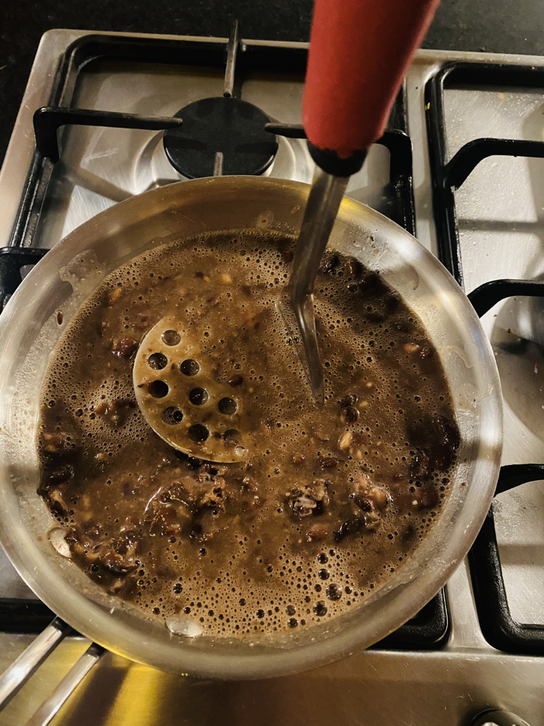 Black beans being mashed by hand