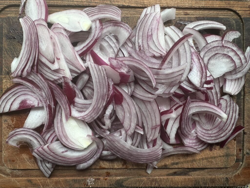 Sliced red onion on a wooden cutting board