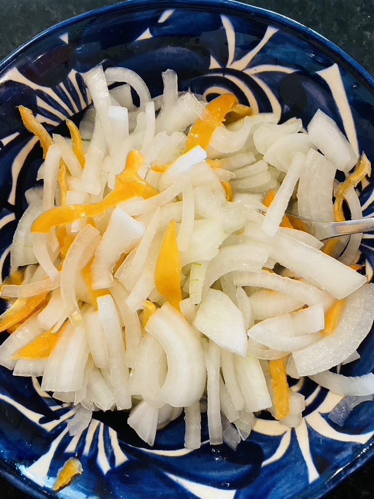 White onions and habanero strips in a blue pottery bowl