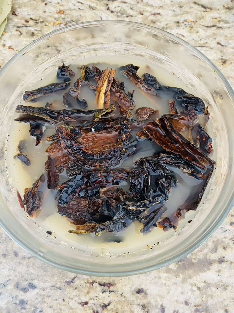 Pasilla chiles soaking in broth
