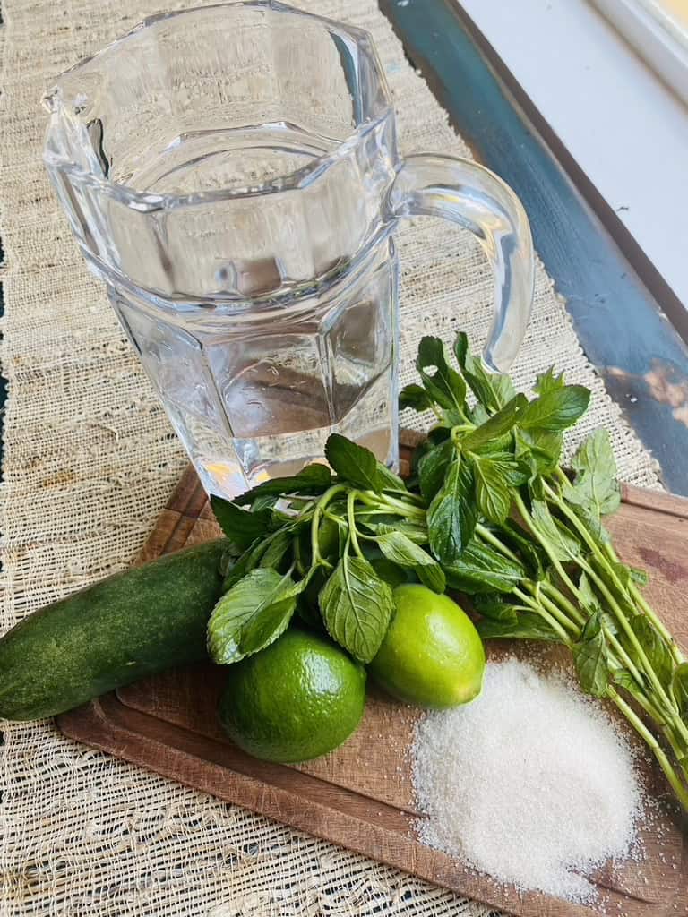 Ingredients for cucumber mint lime, which includes water, sugar, lime, mint leaves, and cucumber