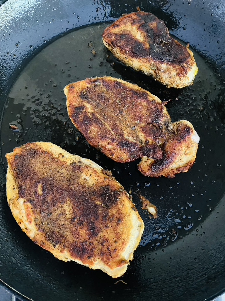 Golden brown chicken breasts for fajitas in a non-stick skillet