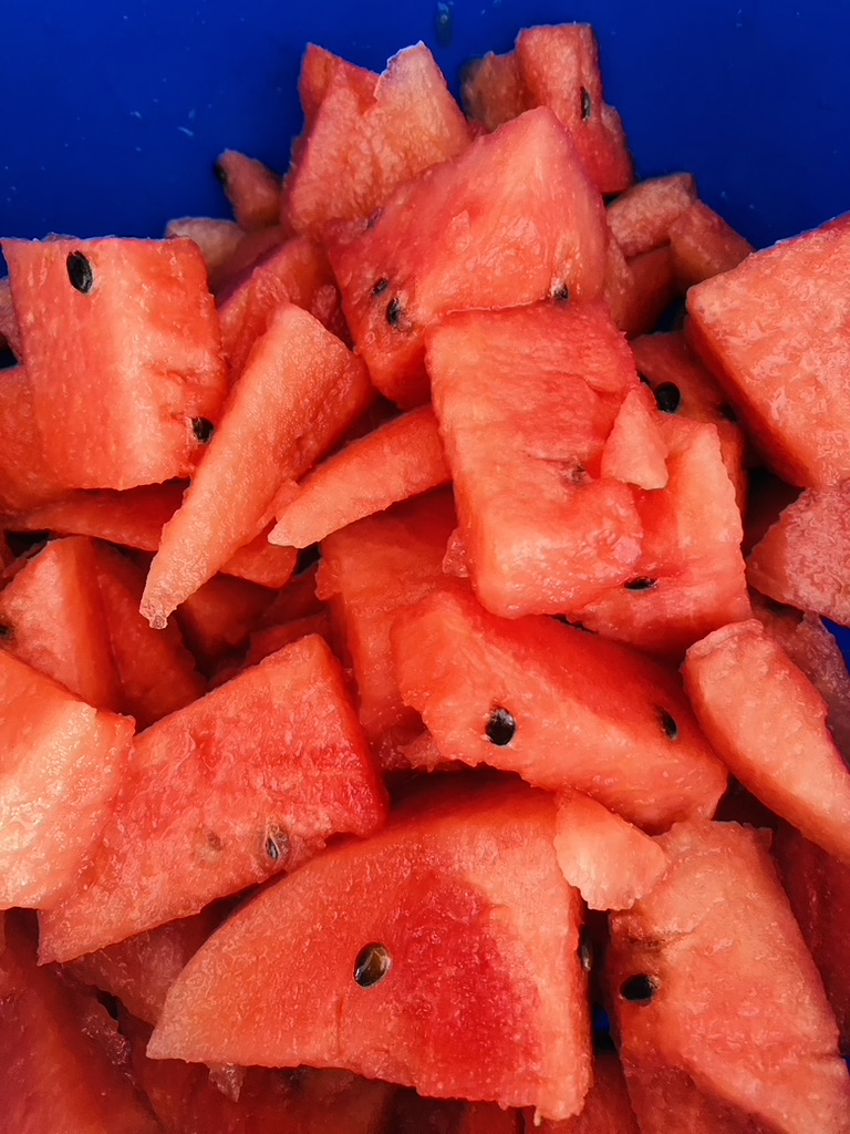 Cut up watermelon pieces in a blue bowl