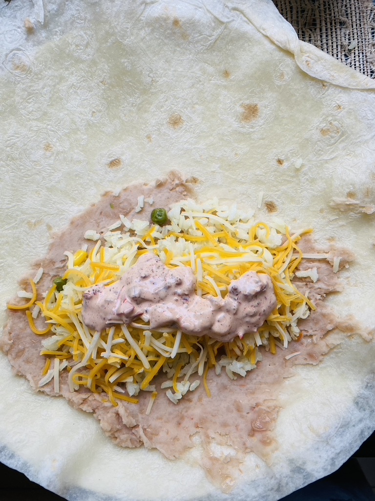 Flour tortilla with refried beans, rice, cheese, and chipotle crema
