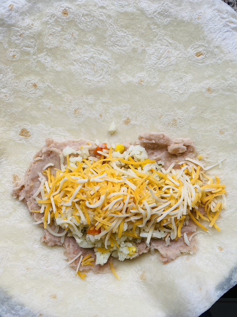 Flour tortilla with refried beans, rice, and cheese