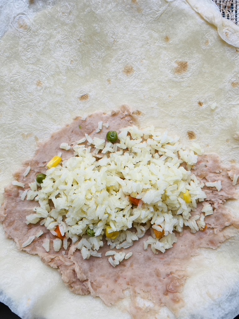 Flour tortilla with refried beans and rice