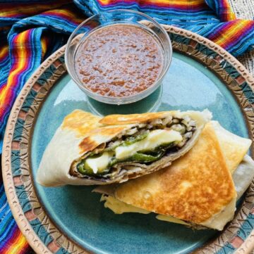 Chile relleno burrito cut in half on a blue pottery plate