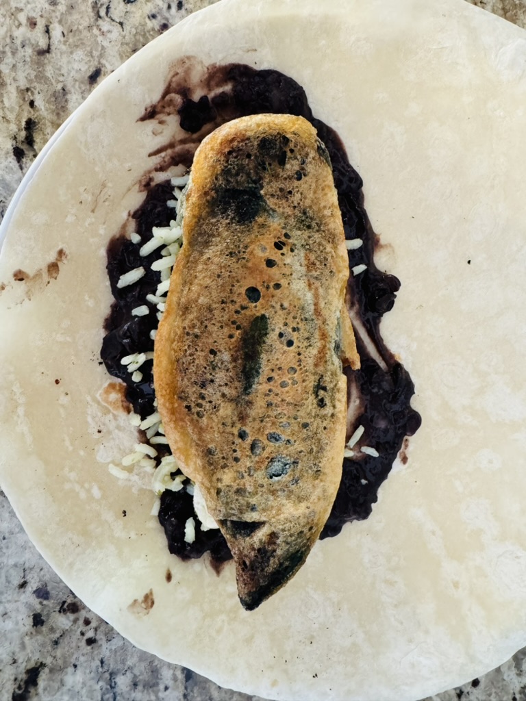 Flour tortilla with refried black beans, rice, and chile relleno