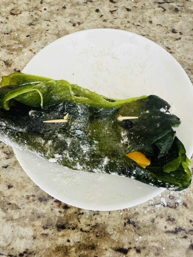 Roasted poblano pepper, cleaned, stuffed with cheese, pinned closed and dusted with flour