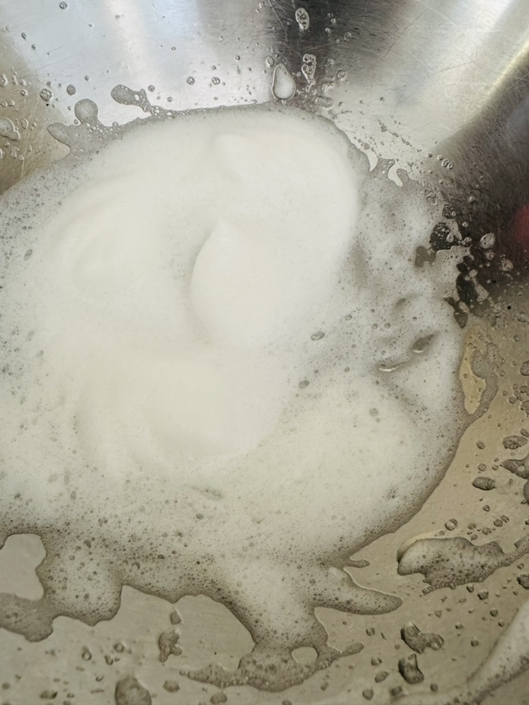 Whipped egg in a stainless steel bowl