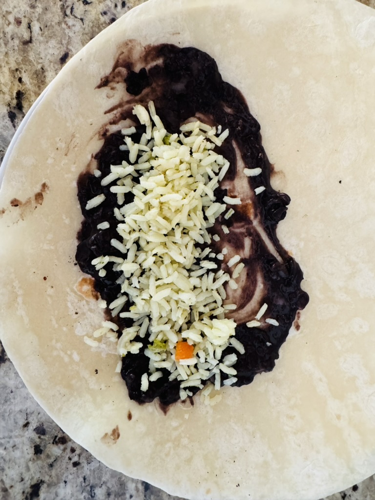 Flour tortilla with black refried beans, and white rice