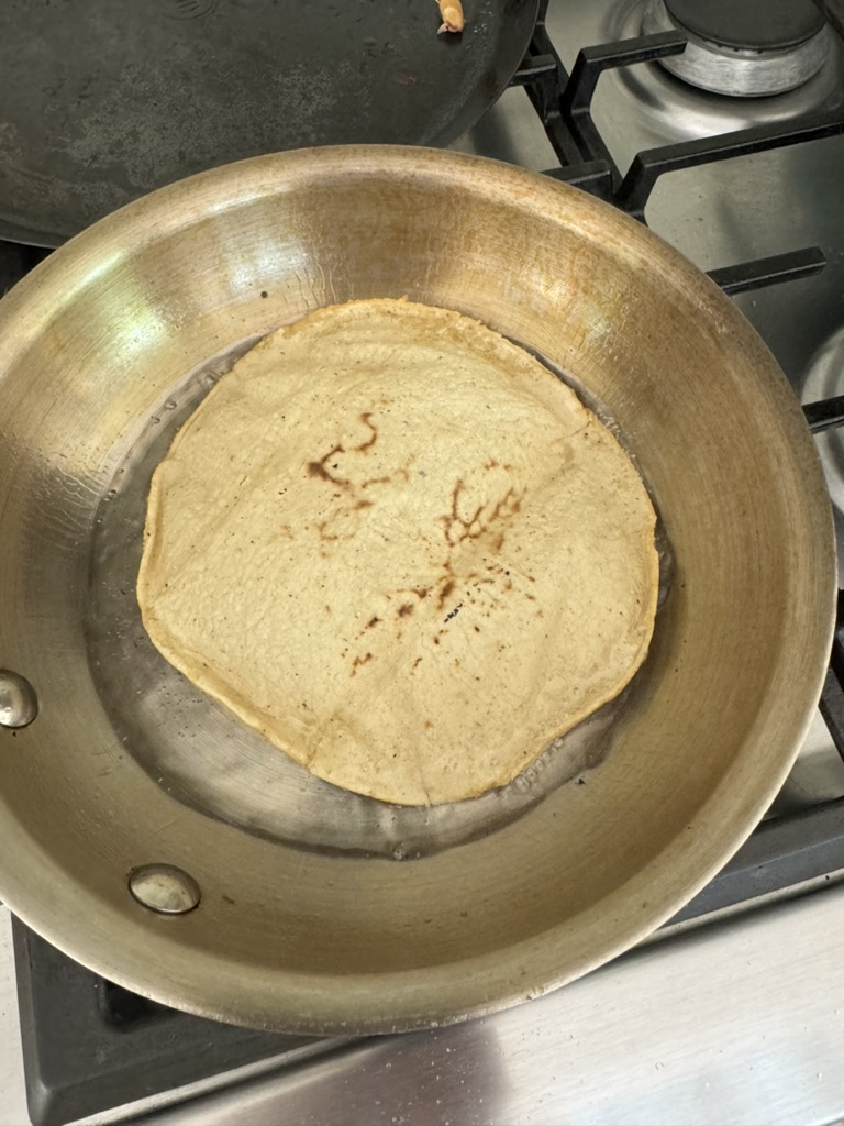 Corn tortilla frying in vegetable oil