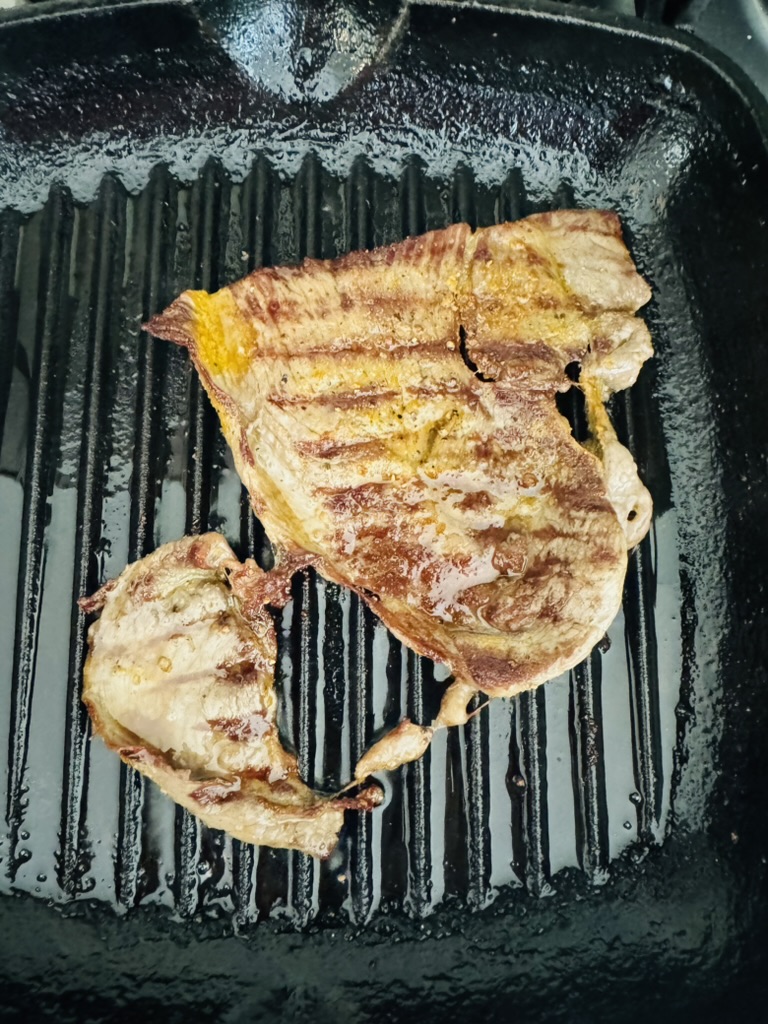 Cooked sirloin steak in a grill pan
