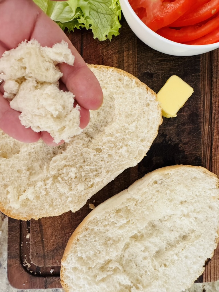 Telera roll sliced lengthwise through center and crumbs removed from soft interior