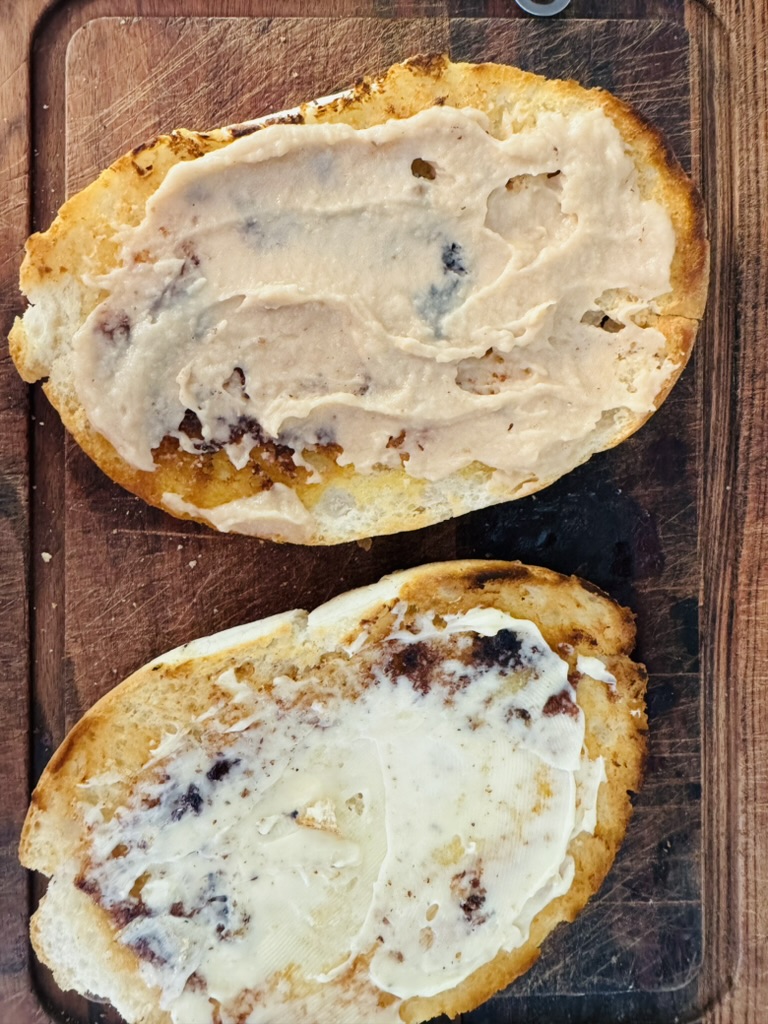One half of the telera with refried beans, the other half with mayonnaise