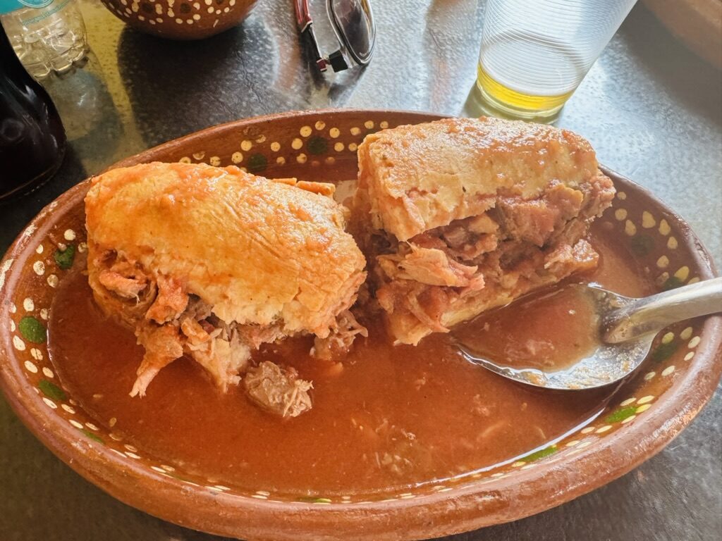 Torta ahogada on a pottery plate