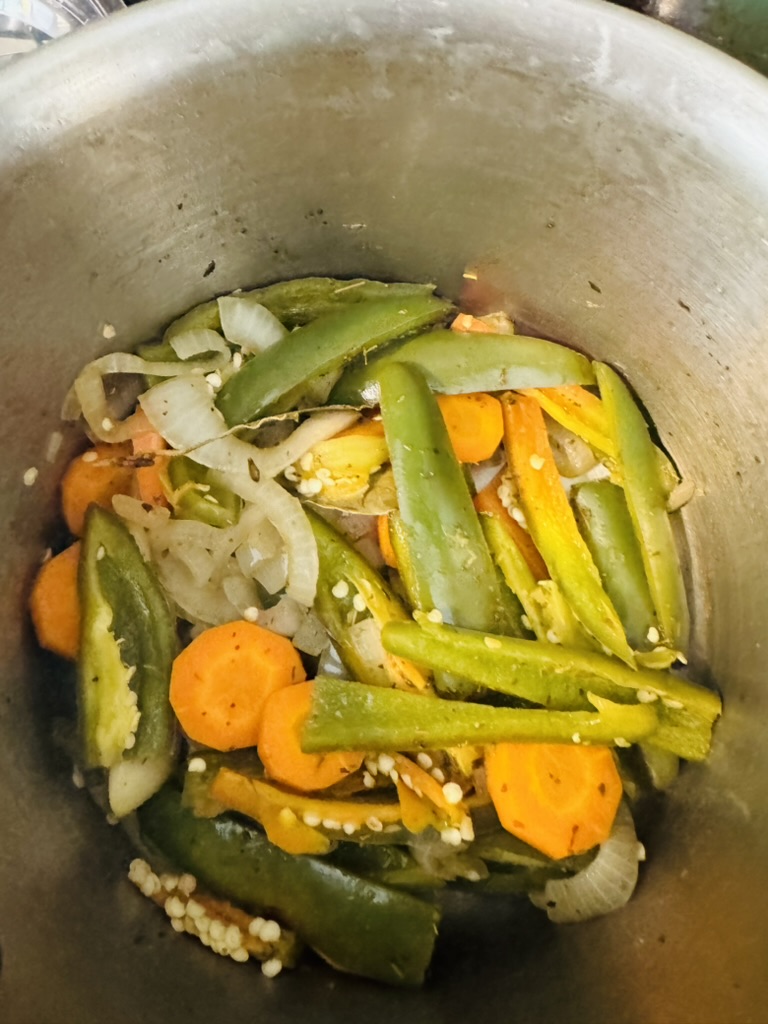 Pickled jalapeños, carrots, and onions cooked in a metal pot