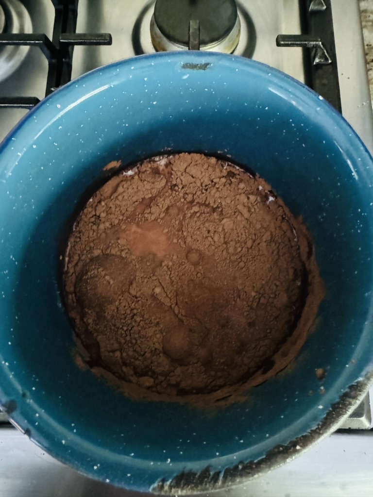 Hot chocolate ingredients in a blue pot on the stove