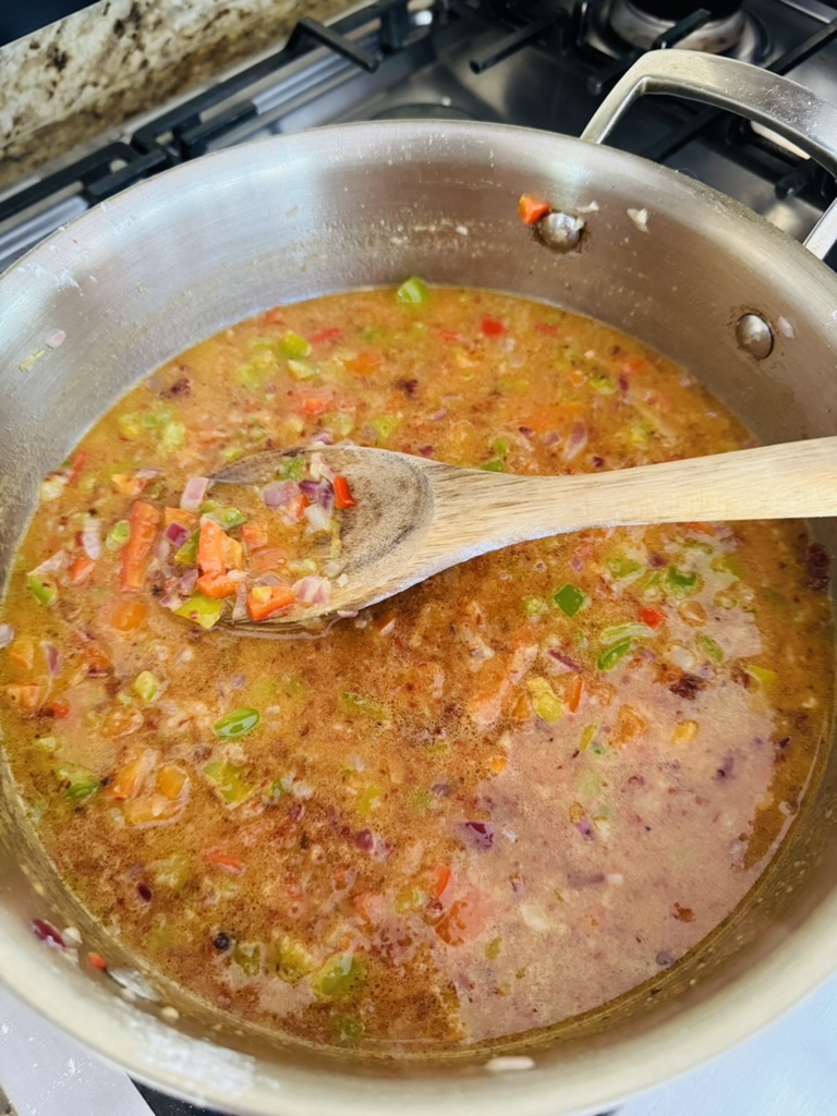 Broth and blended chipotles added to cooked diced peppers and onions